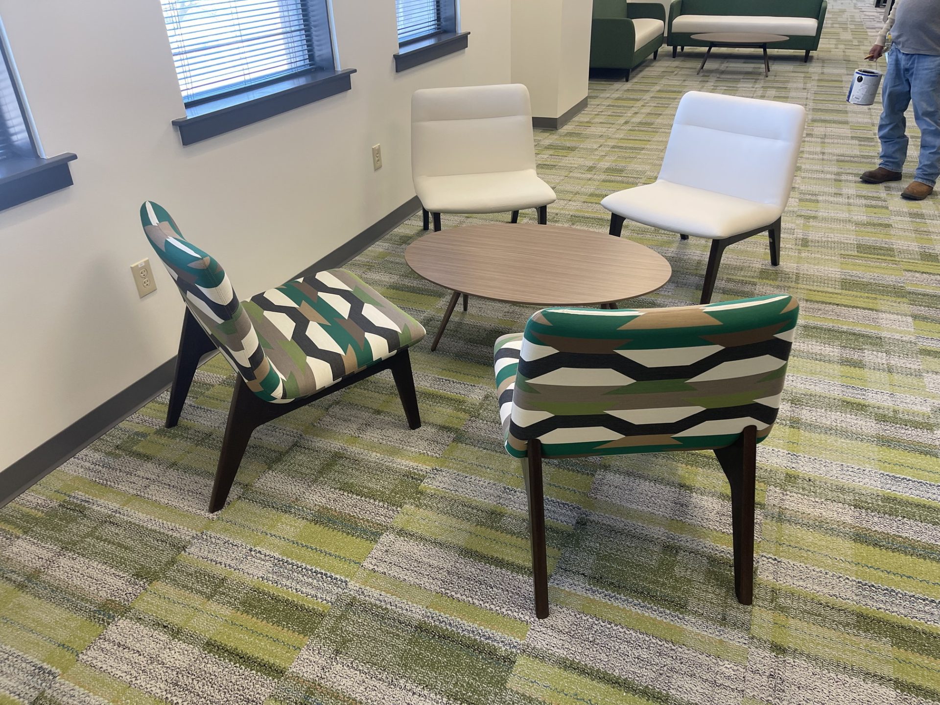 A round table with green and white chairs